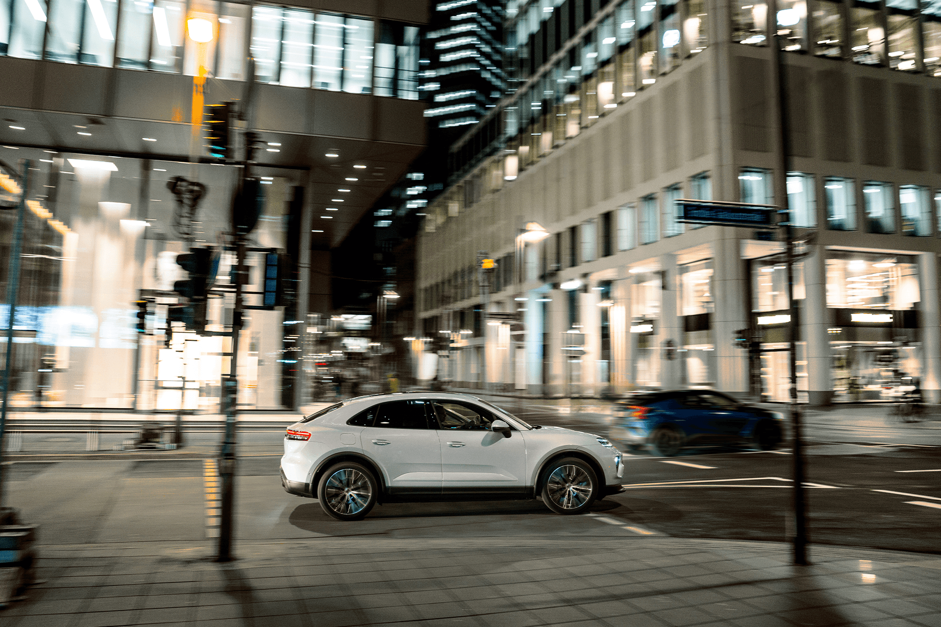 Seitenansicht des Macan 4 während der Fahrt durch die nächtliche Stadt