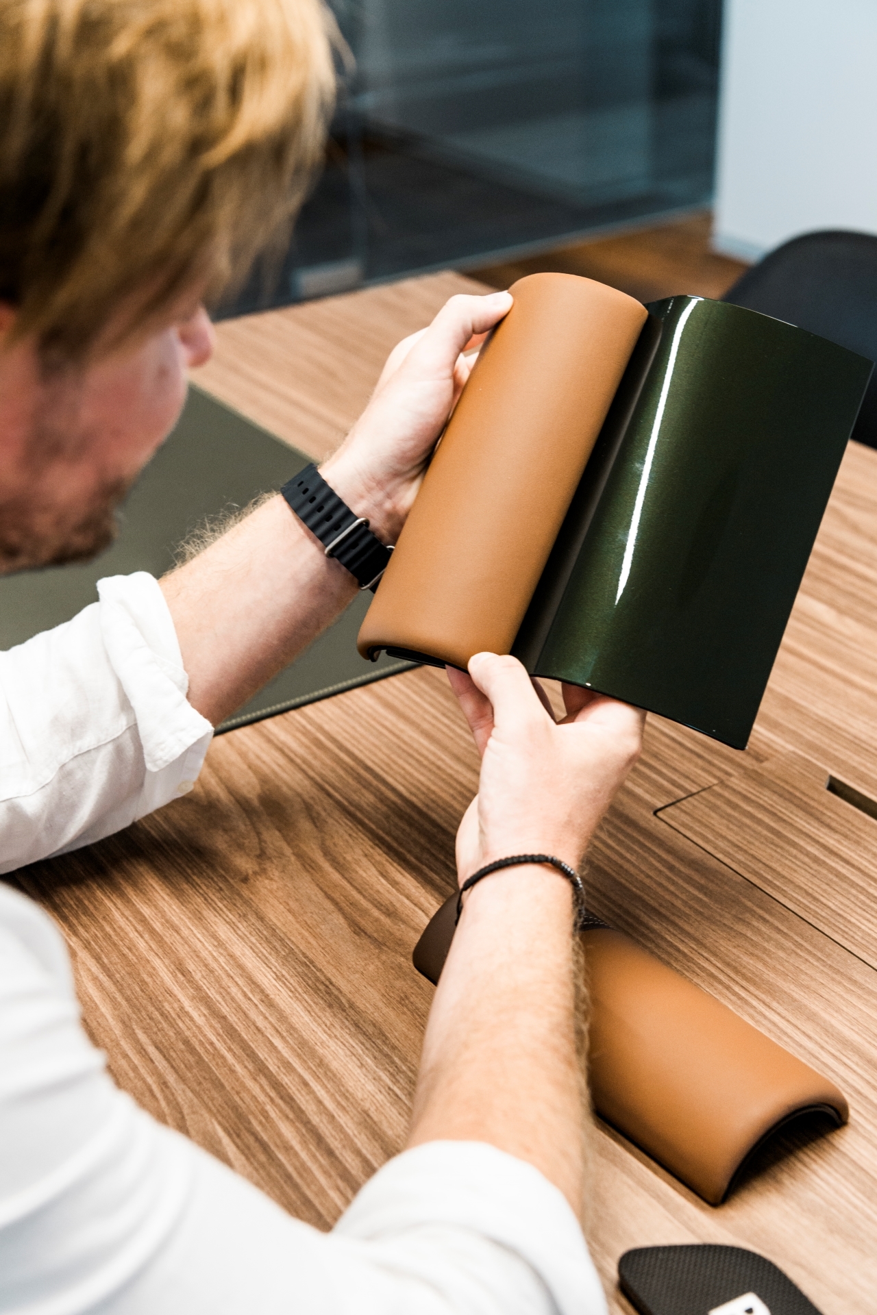 Vladmir Polívka drží v ruce dlaždice s vybranou barvou exteriéru a kůže v interiéru.