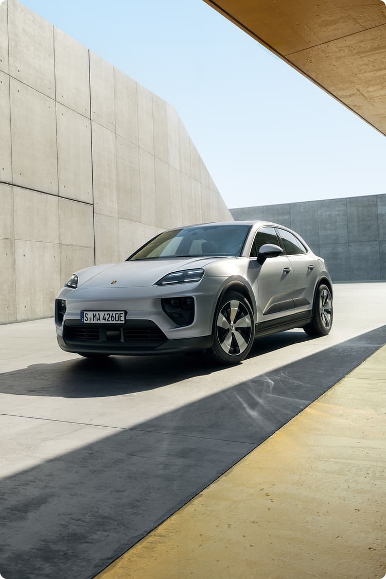 Porsche Macan 4 Ice Grey Metallic -mallissa kolmen neljänneksen näkymässä minimalistiseen betoniarkkitehtuuriin, jossa näkyvät LED-valot.