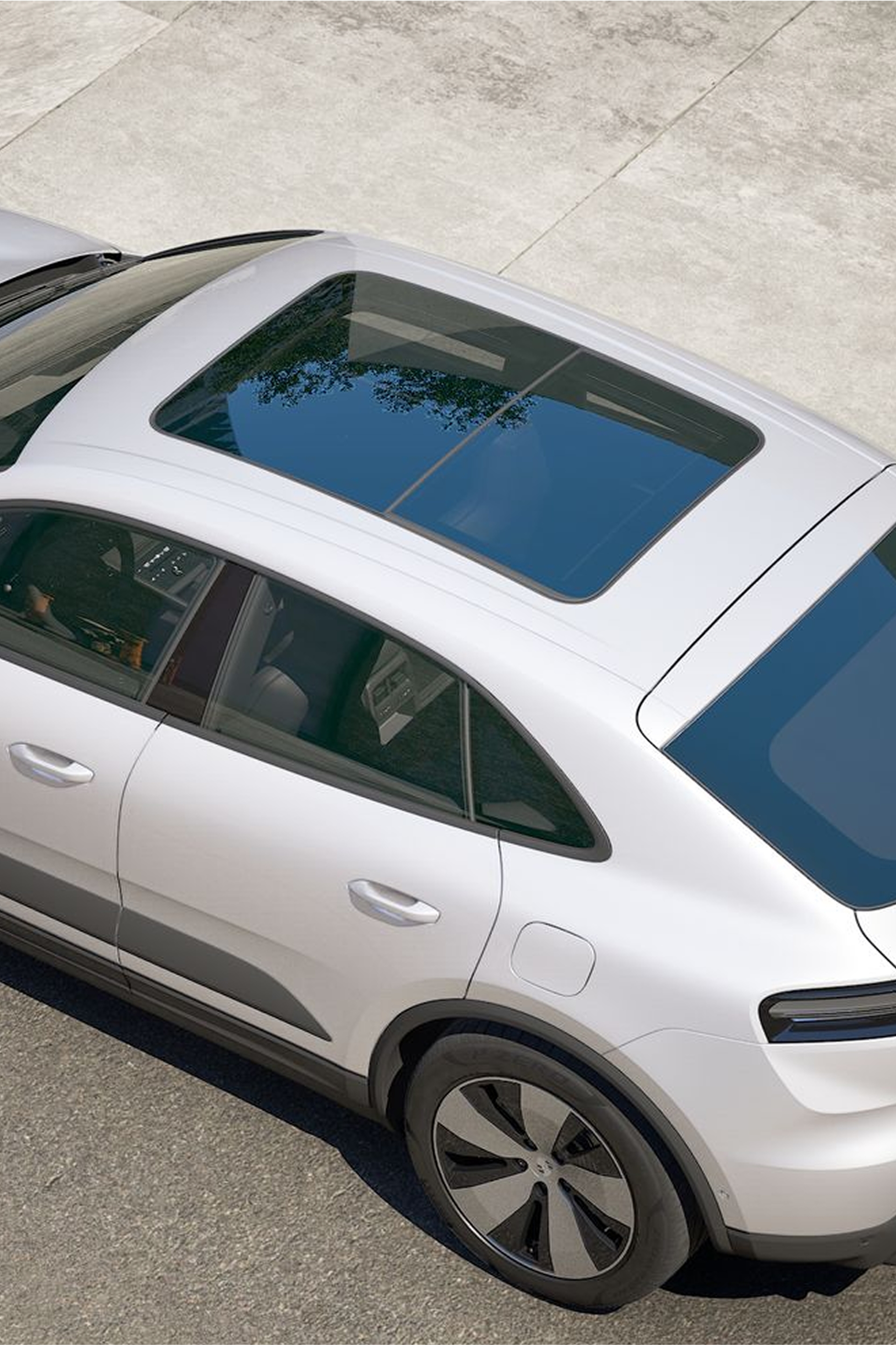 Porsche Macan 4 Ice Grey Metallic -profiili, jossa on sininen panoraaman katto, Advanced Package -ominaisuus, joka näkyy betonin pinnalla ja jossa on luonnonvalo.